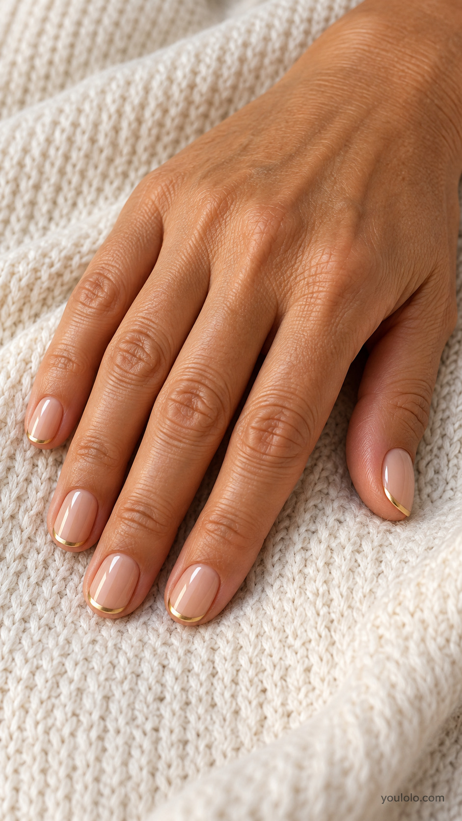 Short nude rounded nails with narrow metallic gold French tips